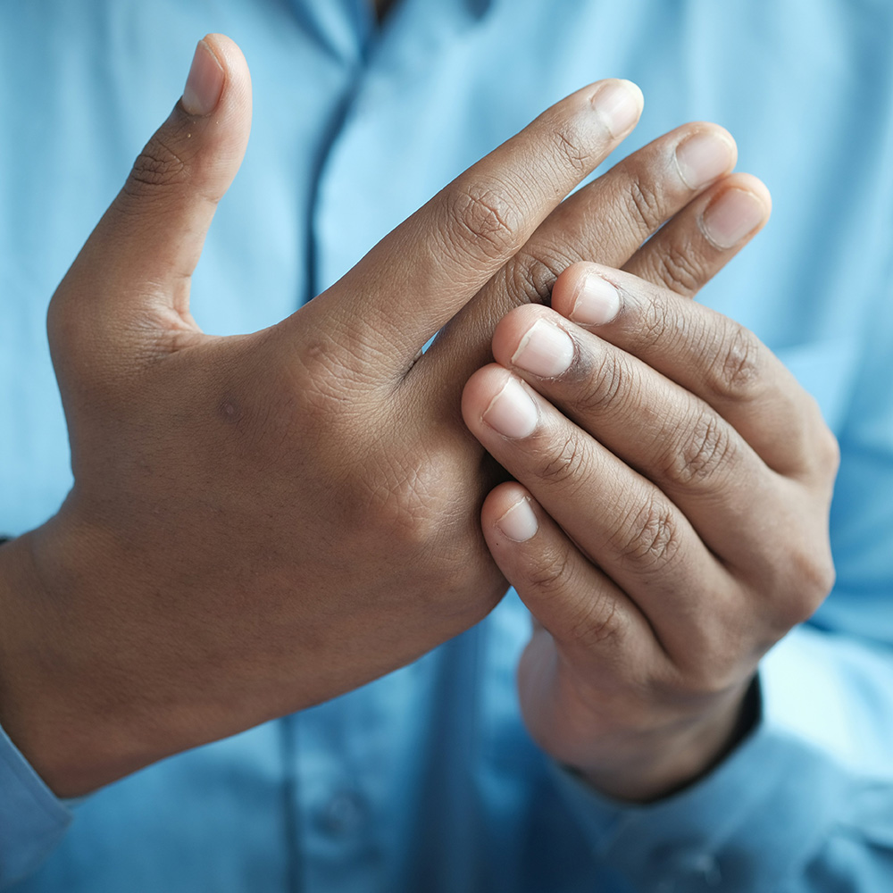 Patient mit Schmerzen im Daumengelenk und Fingerarthrose bei einer Untersuchung der Handfunktion